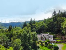 A house surrounded by trees and mountains at Greffyn in Betws-Y-Coed