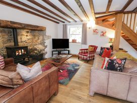 A living room with a fireplace and sofa at Greffyn in Betws-Y-Coed