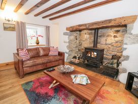 A living room with a sofa and fireplace at Greffyn in Betws-Y-Coed