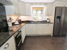 A kitchen with cabinets, sink, and appliances at Greffyn in Betws-Y-Coed
