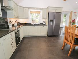 A kitchen with cabinets and appliances at Greffyn in Betws-Y-Coed