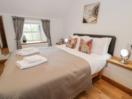 A bedroom with a bed and two lamps at Greffyn in Betws-Y-Coed