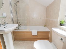 A bathroom with a shower, bathtub, sink, and toilet at Greffyn in Betws-Y-Coed