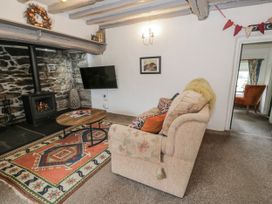 A living room with a sofa and coffee table at Orsedd Wen Farmhouse in Betws-Y-Coed