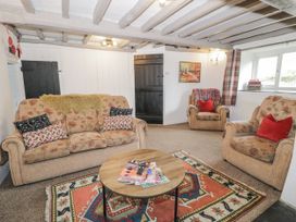 A living room with a sofa and armchairs at Orsedd Wen Farmhouse in Betws-Y-Coed