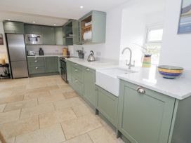 A kitchen with cabinets and appliances at Orsedd Wen Farmhouse in Betws-Y-Coed