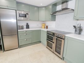 A kitchen with appliances and cabinets at Orsedd Wen Farmhouse in Betws-Y-Coed