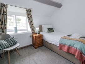 A bedroom with a single bed and nightstand at Orsedd Wen Farmhouse in Betws-Y-Coed