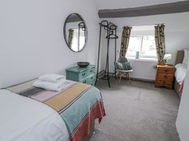 A bedroom with a bed and chair at Orsedd Wen Farmhouse in Betws-Y-Coed