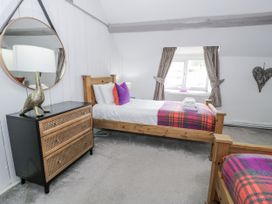 A bedroom with two beds and a dresser at Orsedd Wen Farmhouse Betws-Y-Coed