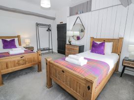 A bedroom with two beds and a lamp at Orsedd Wen Farmhouse in Betws-Y-Coed