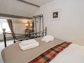 A bedroom with a bed, towels on top, and a clothes rack at Orsedd Wen Farmhouse in Betws-Y-Coed