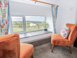 A snug with chairs and a view of a cow at Orsedd Wen Farmhouse Betws-Y-Coed