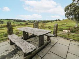 An outdoor area with a stone table and benches at Orsedd Wen Farmhouse in Betws-Y-Coed