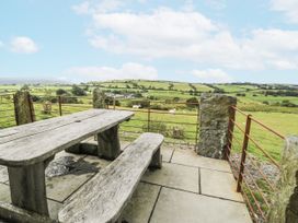 A picnic table and bench with a view of fields at Orsedd Wen Farmhouse Betws-Y-Coed