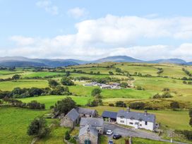 A view of farmland with buildings and hills at Orsedd Wen Farmhouse in Betws-Y-Coed
