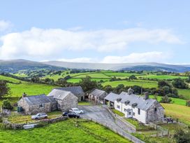 An aerial view of a farmhouse and surrounding landscape at Orsedd Wen Farmhouse in Betws-Y-Coed