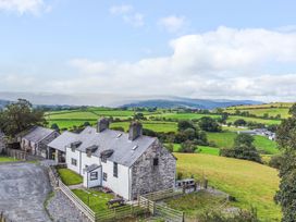 A farmhouse with surrounding fields and mountains at Orsedd Wen Farmhouse Betws-Y-Coed