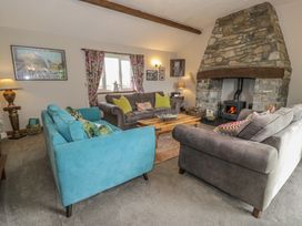 A living room with sofas and a fireplace at Orsedd Wen Cottage in Betws-Y-Coed