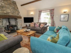 A living room with a fireplace and seating area at Orsedd Wen Cottage in Betws-Y-Coed