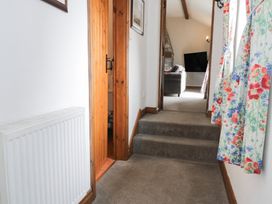 A hallway with stairs and a door at Orsedd Wen Cottage in Betws-Y-Coed