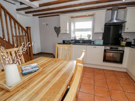 A kitchen with a dining table and chairs at Orsedd Wen Cottage in Betws-Y-Coed