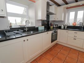 A kitchen with a sink and cabinets at Orsedd Wen Cottage in Betws-Y-Coed