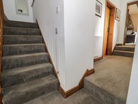A hallway with stairs and a door at Orsedd Wen Cottage in Betws-Y-Coed