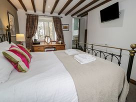 A bedroom with a bed and desk at Orsedd Wen Cottage in Betws-Y-Coed