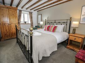 A bedroom with a bed and wardrobe at Orsedd Wen Cottage in Betws-Y-Coed