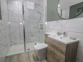 A bathroom with a shower, sink, and toilet at Orsedd Wen Cottage Betws-Y-Coed