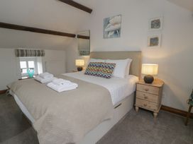 A bedroom with a bed and bedside table with lamp at Orsedd Wen Cottage Betws-Y-Coed