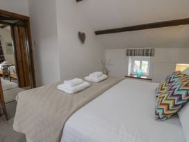 A bedroom with a bed and towels at Orsedd Wen Cottage in Betws-Y-Coed