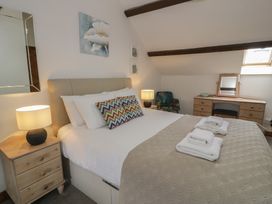 A bedroom with a bed and lamp at Orsedd Wen Cottage in Betws-Y-Coed