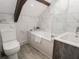 A bathroom with a bathtub, toilet, and sink at Orsedd Wen Cottage in Betws-Y-Coed