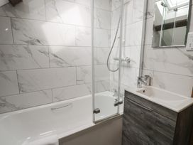 A bathroom with a bathtub and shower at Orsedd Wen Cottage in Betws-Y-Coed