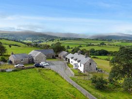 An outdoor area with multiple buildings and vehicles at Orsedd Wen Cottage Betws-Y-Coed