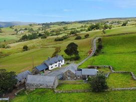 A house surrounded by fields and trees at Orsedd Wen Cottage in Betws-Y-Coed
