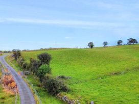A landscape with a winding road and green hills at Orsedd Wen Cottage in Betws-Y-Coed