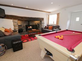 A living room with a pool table and fireplace at Cwm in Capel Curig