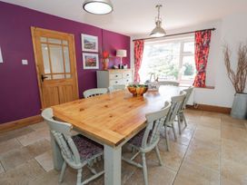 A dining room with a wooden table and chairs at Cwm in Capel Curig