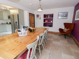 A dining room with a wooden table and chairs at Cwm in Capel Curig