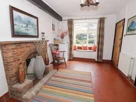 A living room with a fireplace and chair at Cwm in Capel Curig