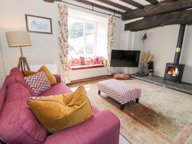 A living room with a sofa and wood stove at Cwm in Capel Curig