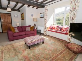A living room with a sofa and footstool at Cwm in Capel Curig