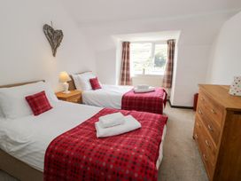 A bedroom with two beds and a lamp at Cwm in Capel Curig