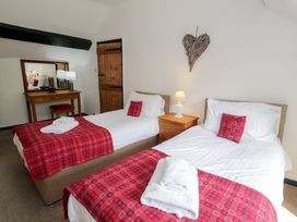 A bedroom with two beds and a mirror at Cwm in Capel Curig