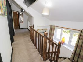 A hallway with a staircase and window at Cwm in Capel Curig