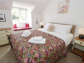 A bedroom with a bed and window seats at Cwm in Capel Curig