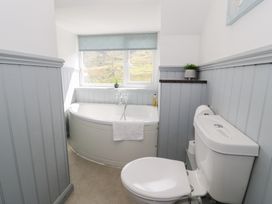 A bathroom with a bathtub and toilet at Cwm in Capel Curig